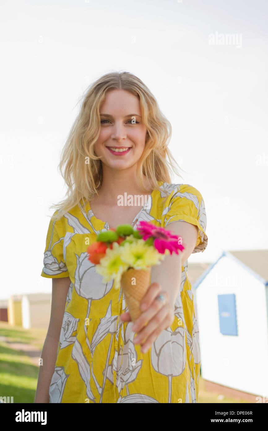 Portrait de jeune femme avec cône de fleurs, Whitstable, Kent, UK Banque D'Images