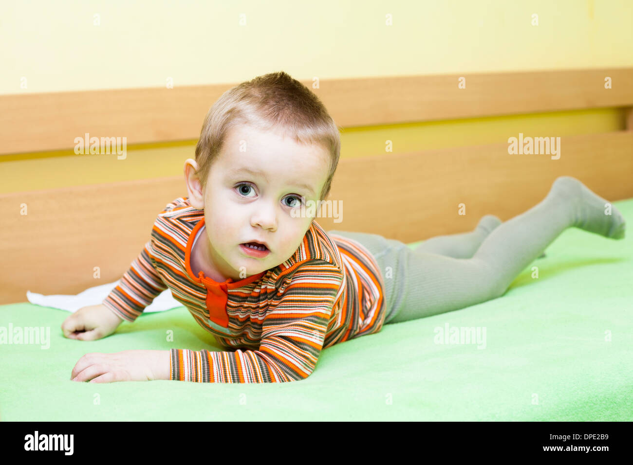 Cute child boy lying on bed at home Banque D'Images