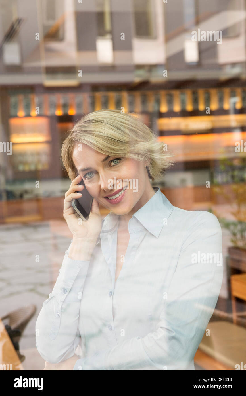 Businesswoman sur appel téléphonique, vue à travers la vitre Banque D'Images
