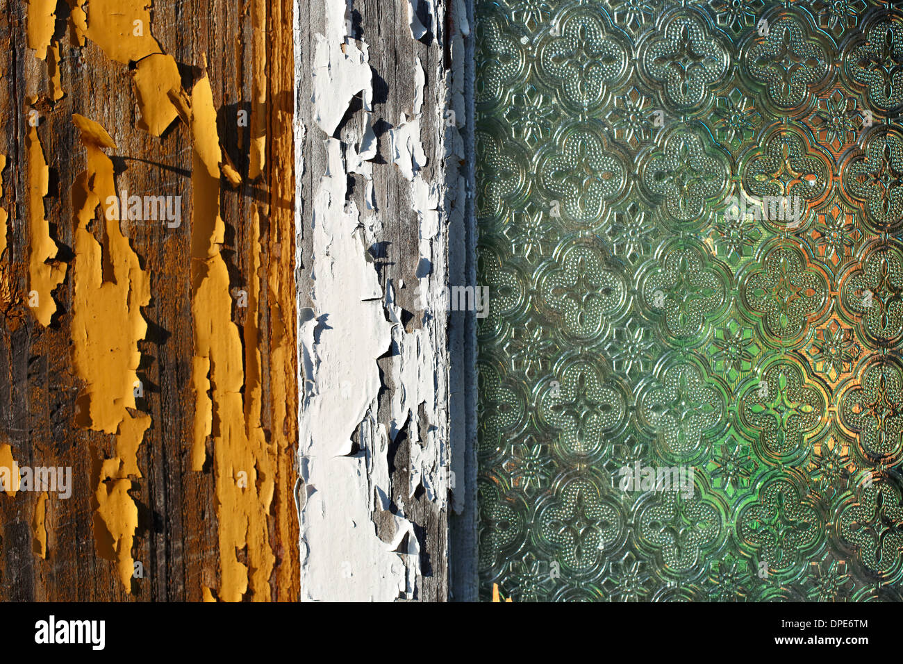 Une photo en gros plan d'une vieille maison de bois fenêtre avec la peinture pèle du vieux et la fenêtre en verre décoré Banque D'Images