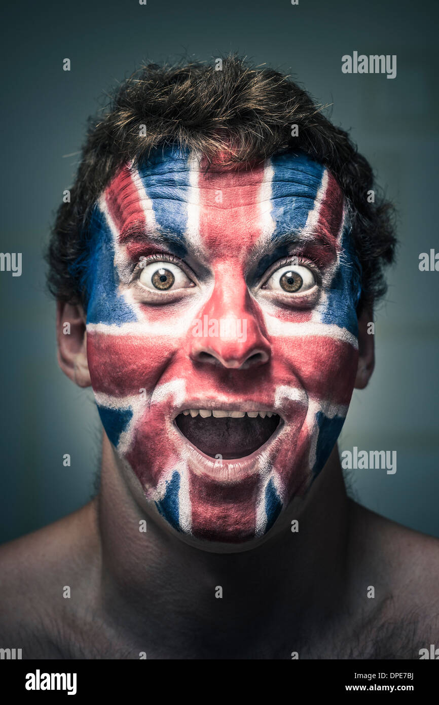 Portrait d'homme choqué avec drapeau anglais peint sur le visage. Banque D'Images