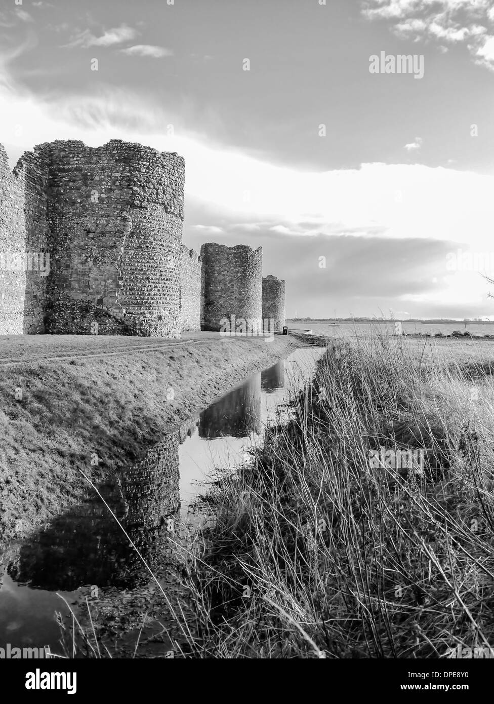 Les remparts romains de Portchester Castle se reflètent dans les douves qui a été récemment renouvelé par les marées extrêmement élevé Banque D'Images