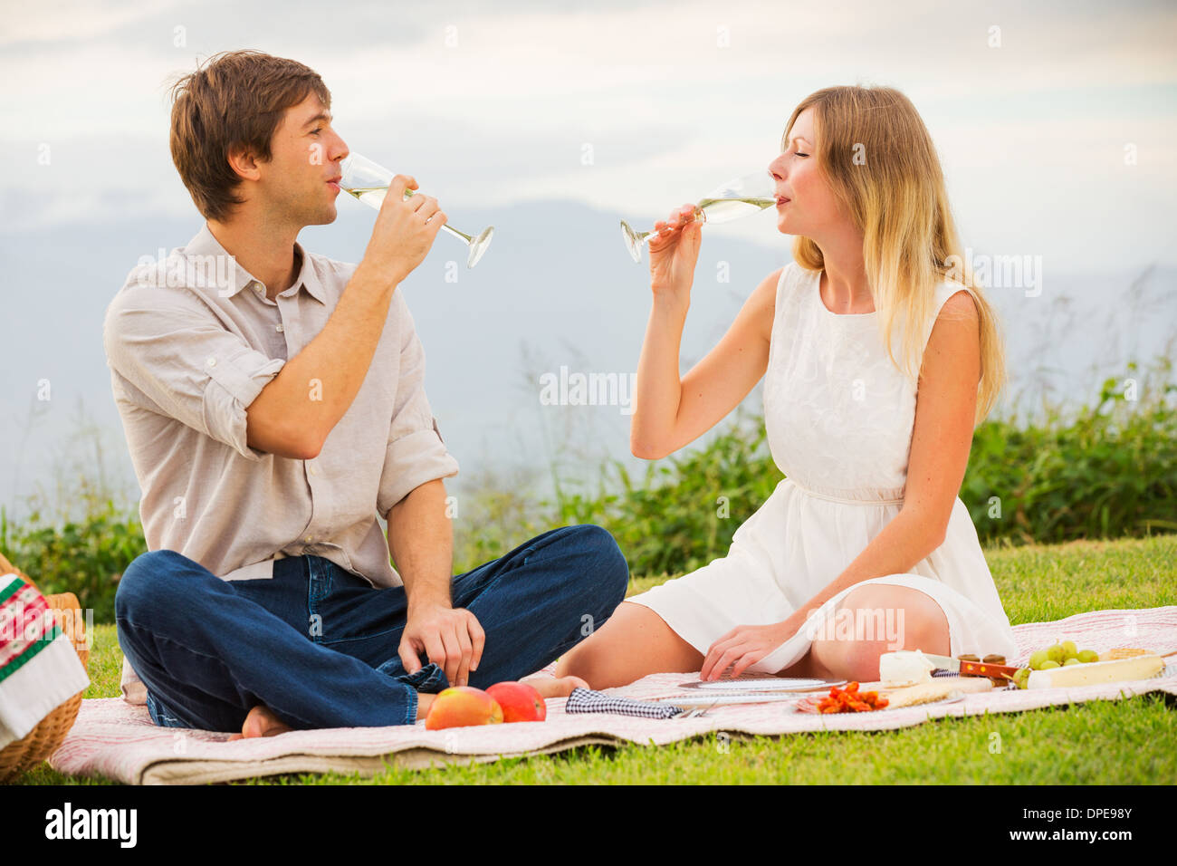 Beau couple Enjoying romantique coucher de soleil pique-nique dans la campagne Banque D'Images