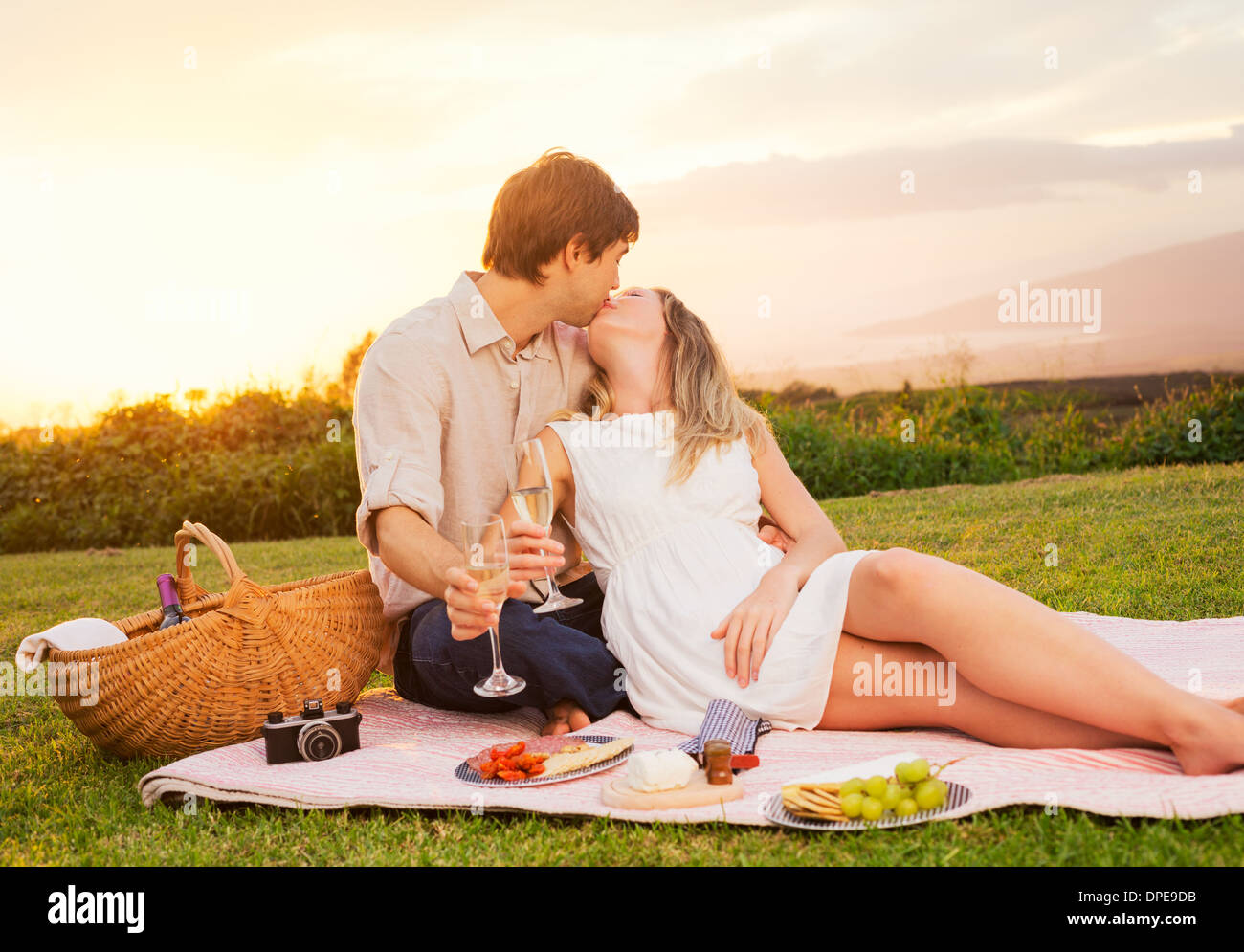 Beau couple Enjoying romantique coucher de soleil pique-nique dans la campagne Banque D'Images