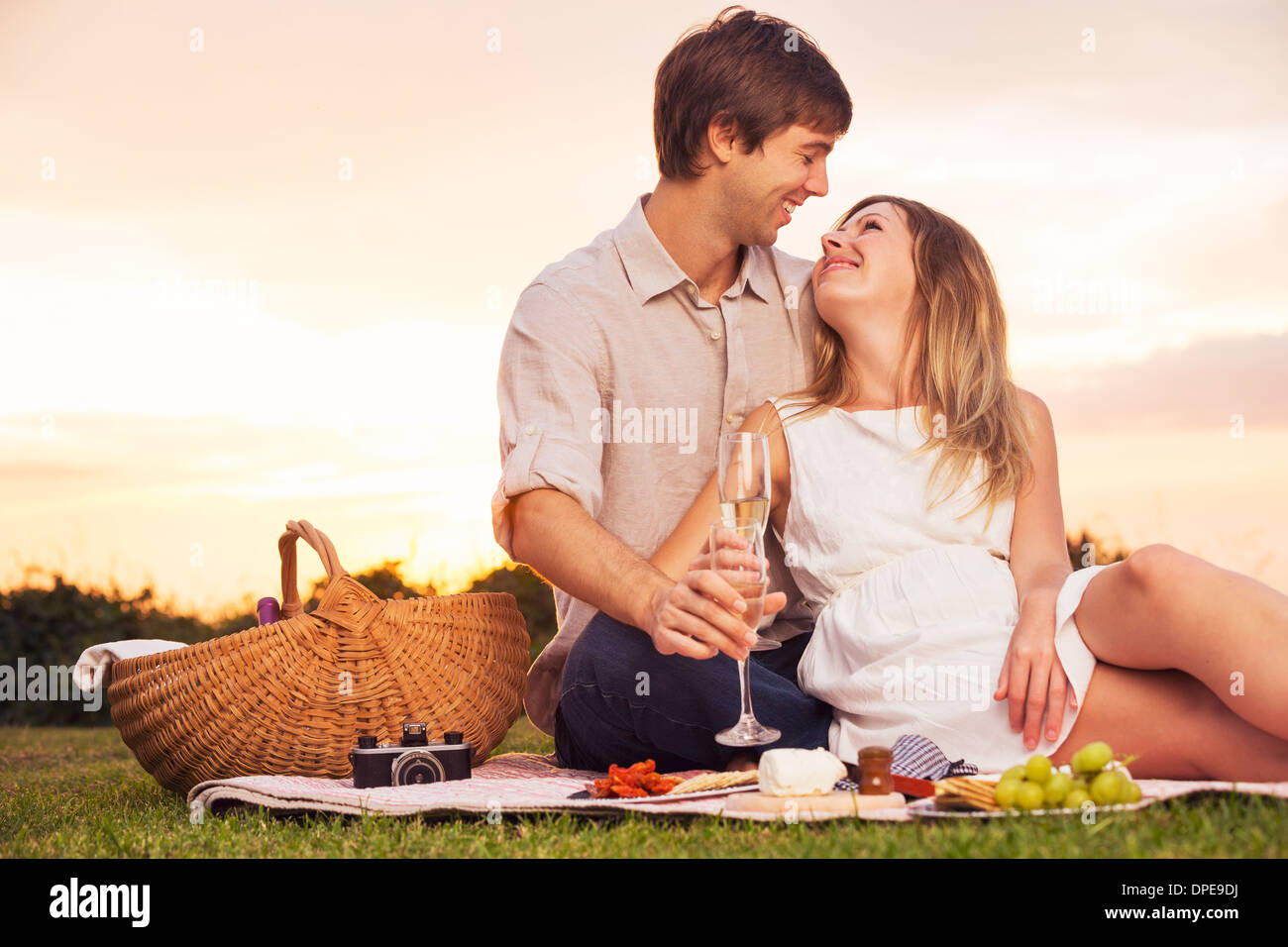 Beau couple Enjoying romantique coucher de soleil pique-nique dans la campagne Banque D'Images