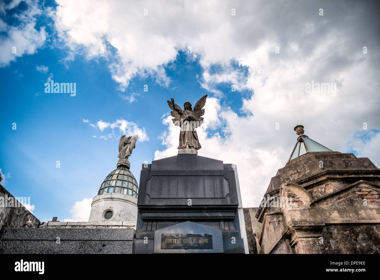 Cimetière de Recoleta Statue d'ange Buenos Aires Argentine // BUENOS AIRES, Argentine — une statue d'ange couronne le mausolée Cortese Guglielmone dans le cimetière de Recoleta (Cementerio de la Recoleta). Cet élément sculptural représente un motif commun dans l'art funéraire du XIXe siècle, où les anges symbolisent souvent la protection divine et l'orientation. La statue illustre les sculptures mémoriales élaborées qui caractérisent le patrimoine architectural de ce cimetière historique. Banque D'Images