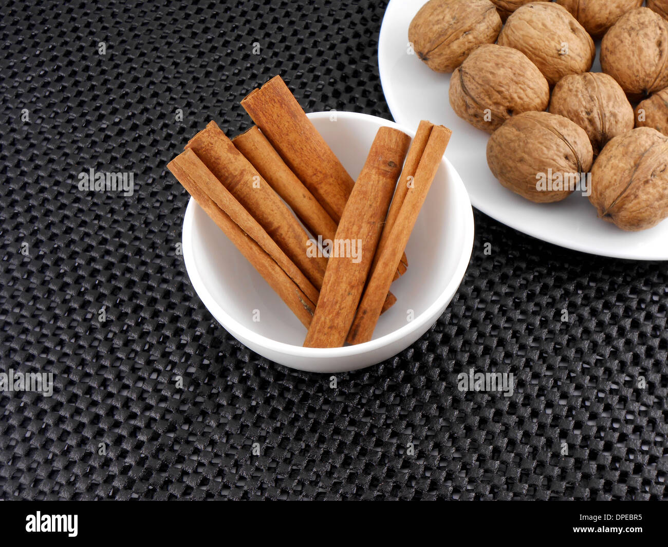 Jeu de noix et de cannelle set on white plate Banque D'Images