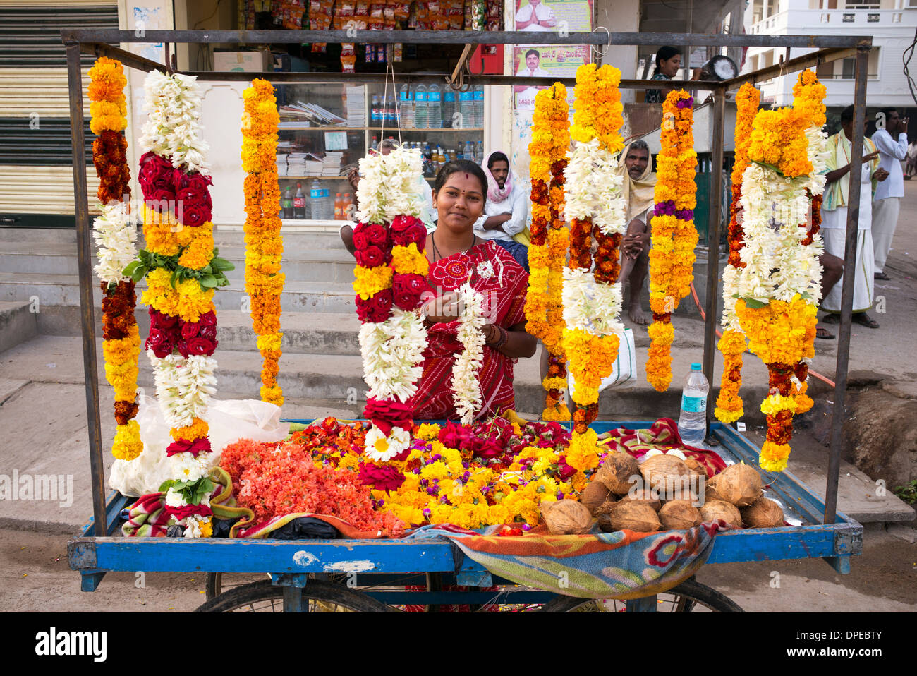 Femme indienne la vente de fleurs et de guirlandes pour hindu temple culte. Puttaparthi, Andhra Pradesh, Inde Banque D'Images