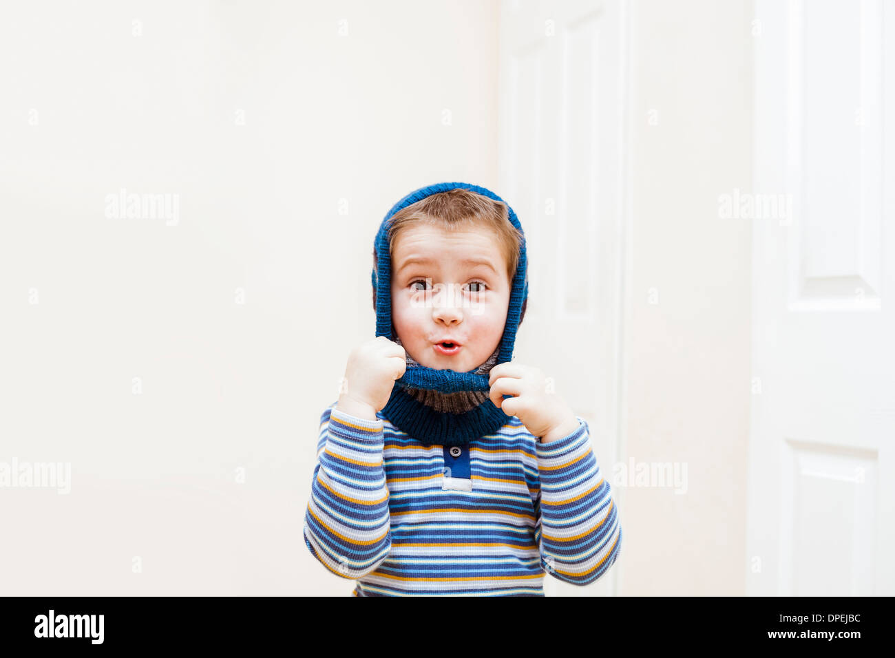 Happy child boy wearing winter hat indoors Banque D'Images