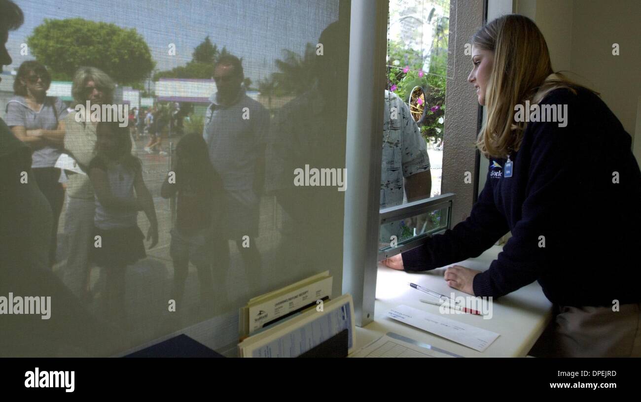 (Publié le 06/19/2004, E-1:1,2,6,7 ; UT1814694) hôtesse guest relations Katrina Cherry (à droite) permet aux clients de la queue (à gauche) à la fenêtre d'entrée annuelle à Sea World, le samedi matin. UT photo par Eduardo Contreras Banque D'Images