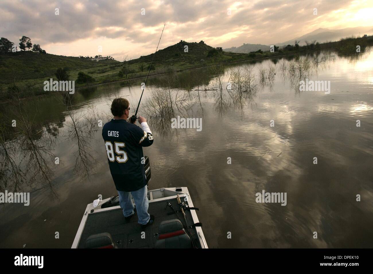 (Publié le 03/03/2005, D-1)Floating parmi les cimes des arbres à l'ouest de l'autoroute I-15 dans la région de Lake Hodges, pêcheur John Curry de poissons bass comme le soleil se lève (à l'arrière-plan à droite) sur le mercredi matin. C'est la première fois depuis 2001 bateaux ont été allowedon le lac. Le lac était d'environ 20 pieds de profondeur à ce point. En décembre, cette région était sèche. UT photo par Eduardo Contreras Banque D'Images