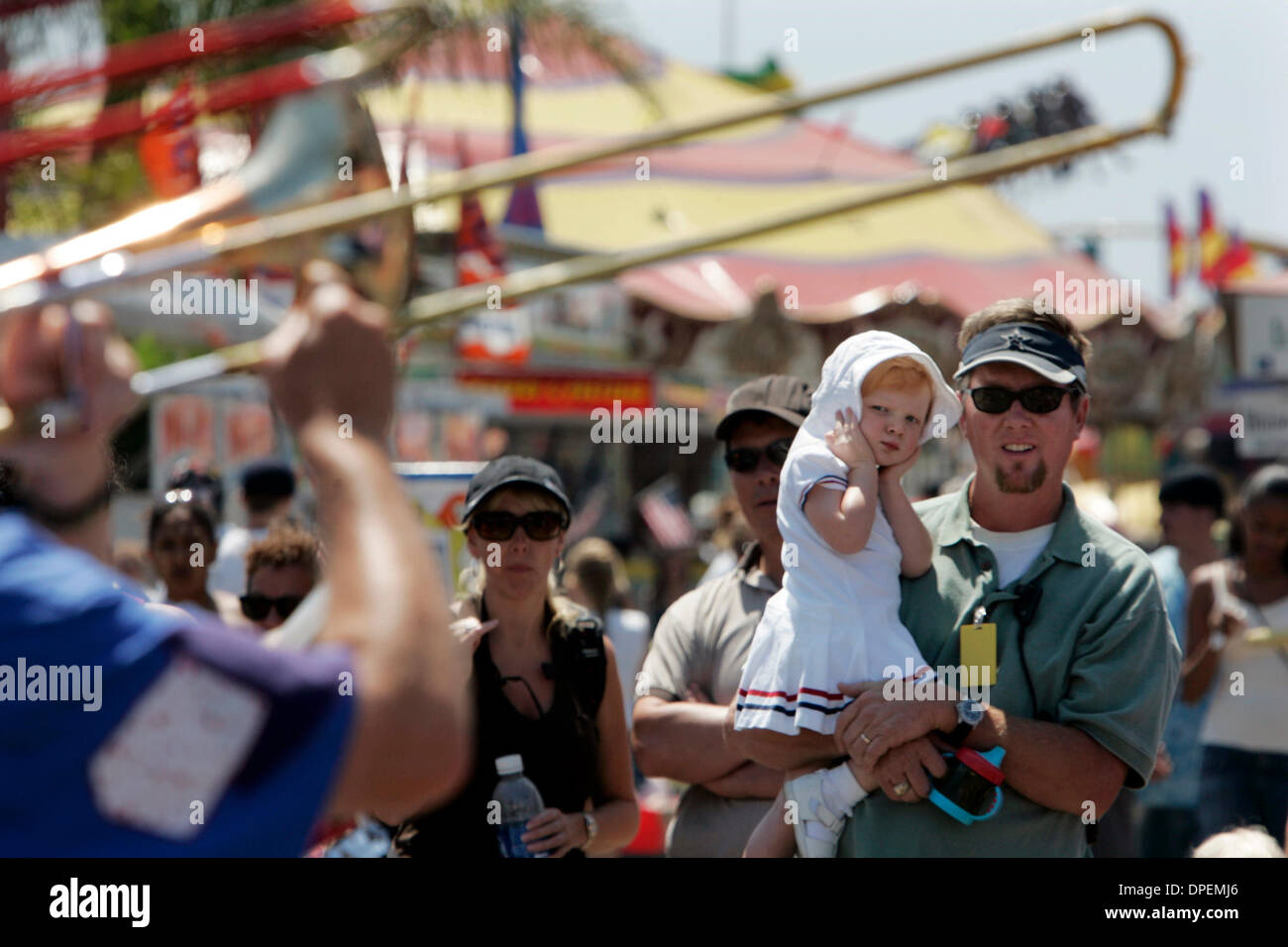 (Publié le 7/31/2006, B-1) le 4 juillet 2006, Del Mar, CA. USA Le trottoir Stompers Bande Clown a attiré une foule mardi à la foire du comté de San Diego, mais ELLA BECK, 2, gardé ses mains à ses oreilles, pendant l'exécution. Son père RUSSELL BECK, travaille à la section à mi-chemin de la foire. Crédit obligatoire : photo par Peggy Peattie/San Diego Union-Tribune/Zuma Press. copyright 2006 San Diego l'Uni Banque D'Images