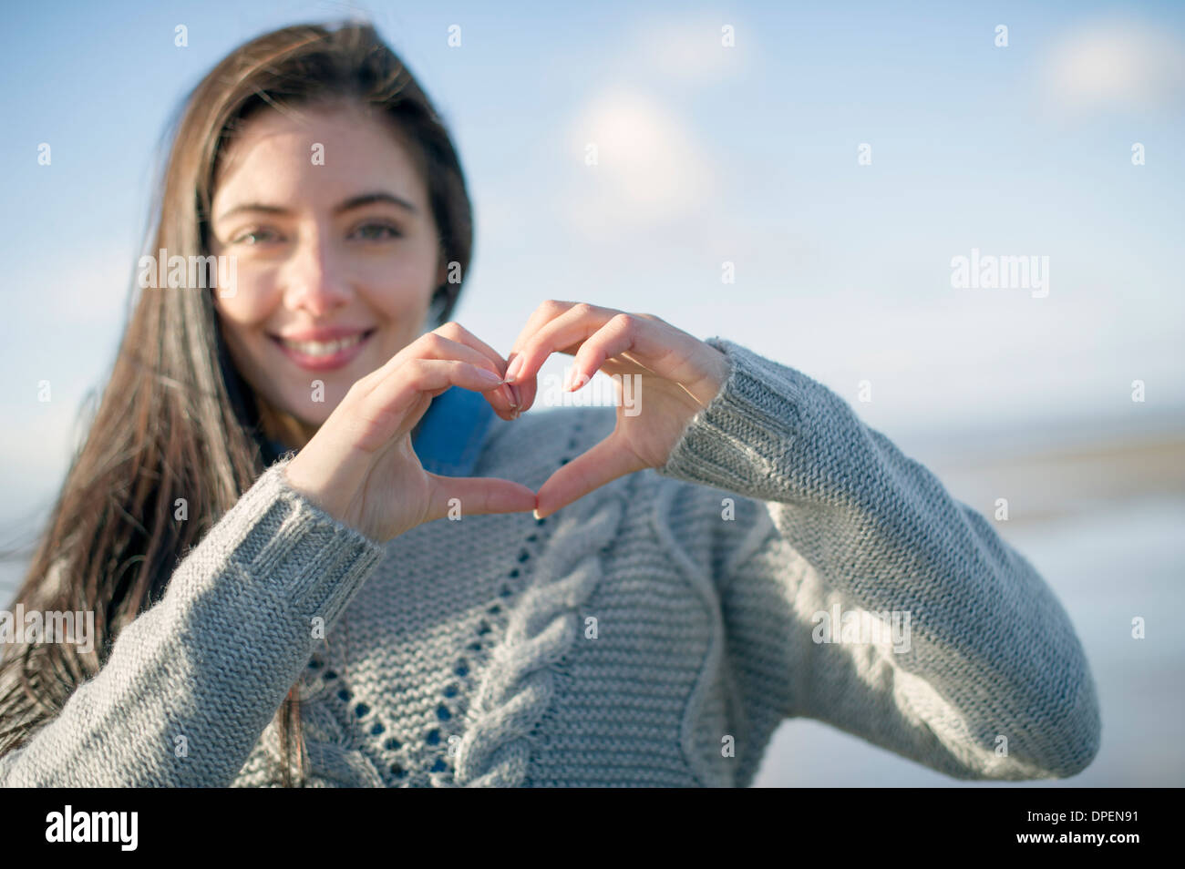 Young woman making heart shape with hands Banque D'Images