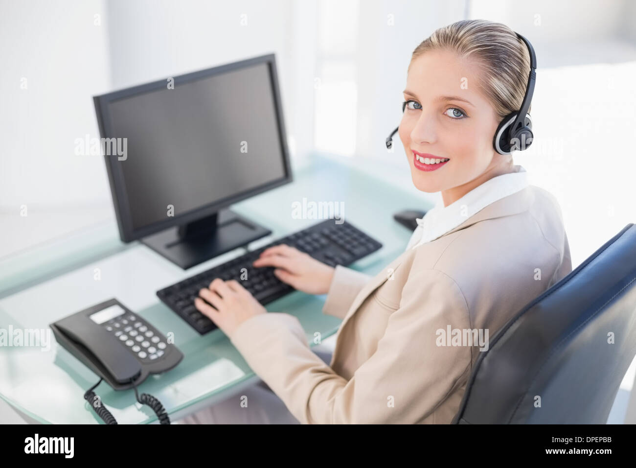 Smiling blonde agent du centre d'appel entrant Banque D'Images