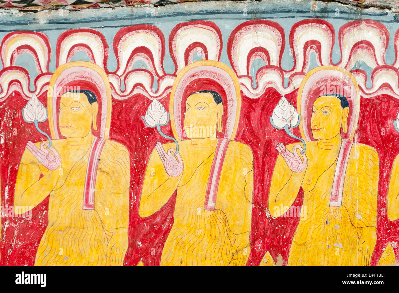 Peinture murale colorée, fresque, trois moines debout à côté de l'autre tenant une fleur de lotus dans une main Banque D'Images