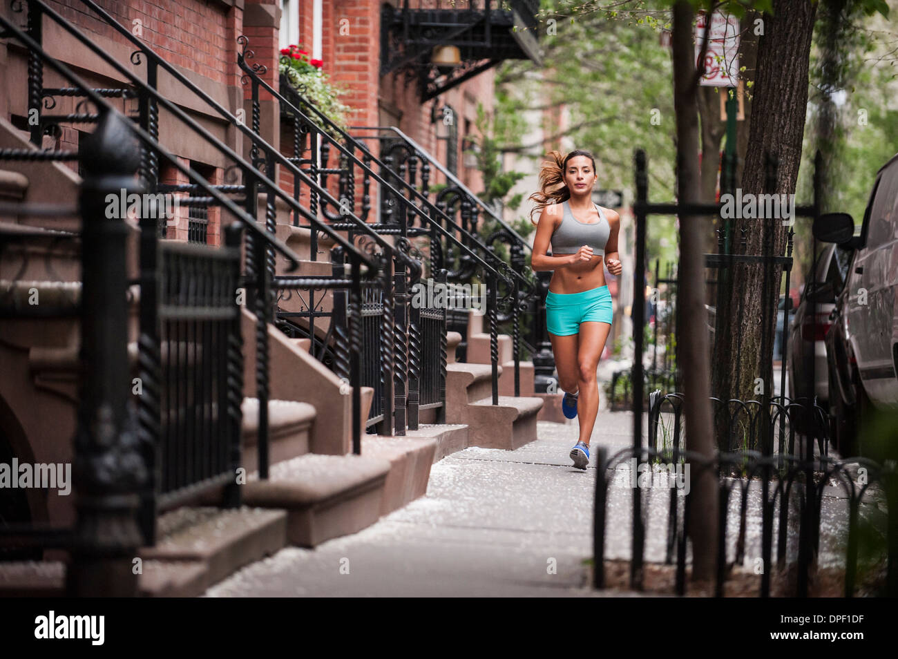 Woman jogging on sidewalk Banque D'Images