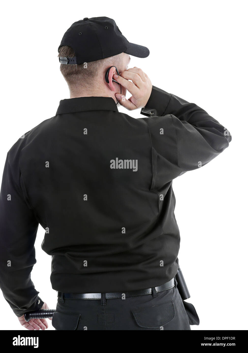 Homme portant l'uniforme noir de sécurité communique à l'aide de casque Banque D'Images
