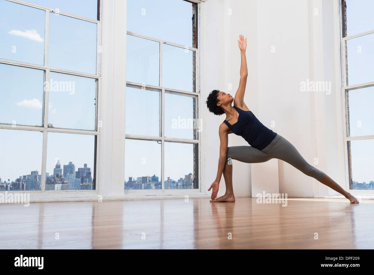 Woman practicing yoga in room Banque D'Images
