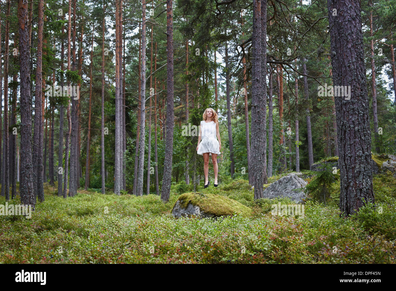 Teenage girl jumping in forest Banque D'Images