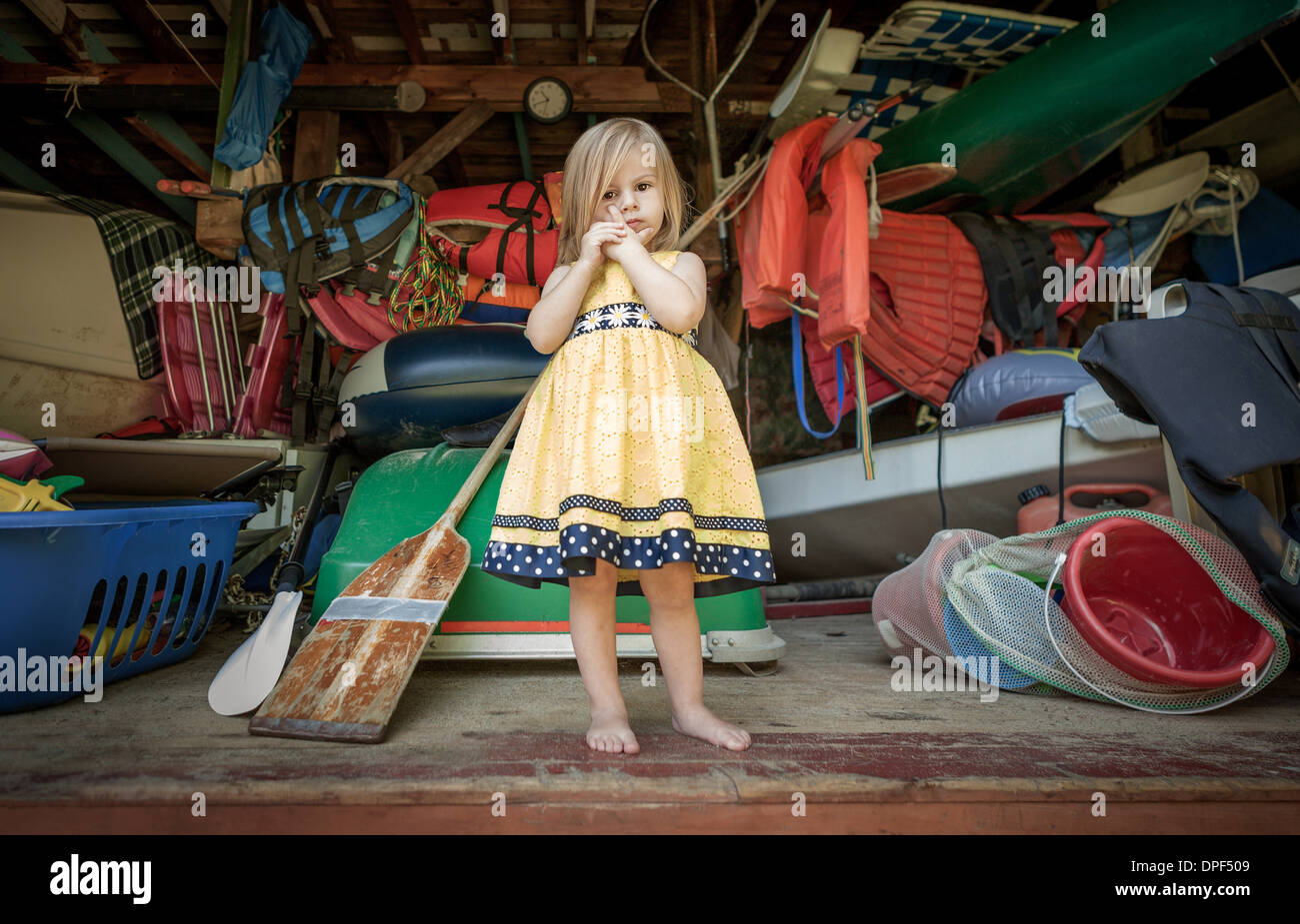 Portrait of female toddler debout à l'avant du garage de stockage Banque D'Images