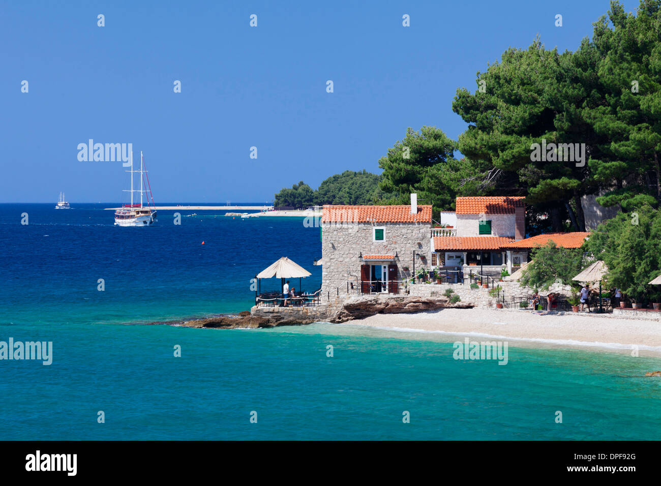 Restaurant à la plage avec bateau à voile, Bol, Île de Brac, la Dalmatie, Croatie, Europe Banque D'Images