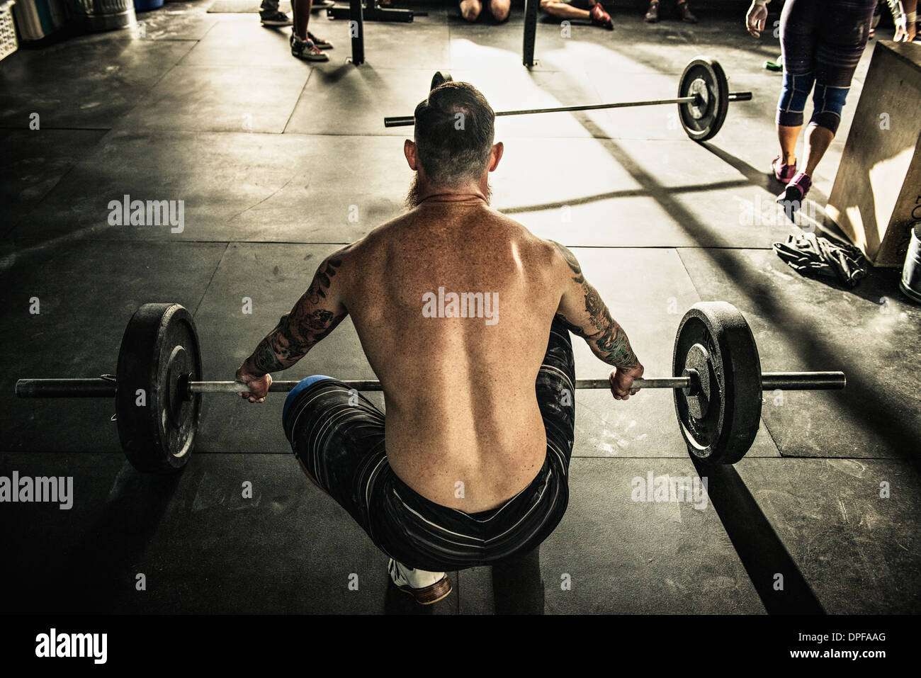 Mid adult man préparez à soulever barbell in gymnasium Banque D'Images