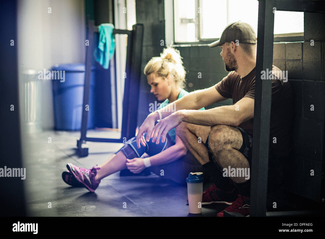 Jeune femme parlant à Trainer in gymnasium Banque D'Images