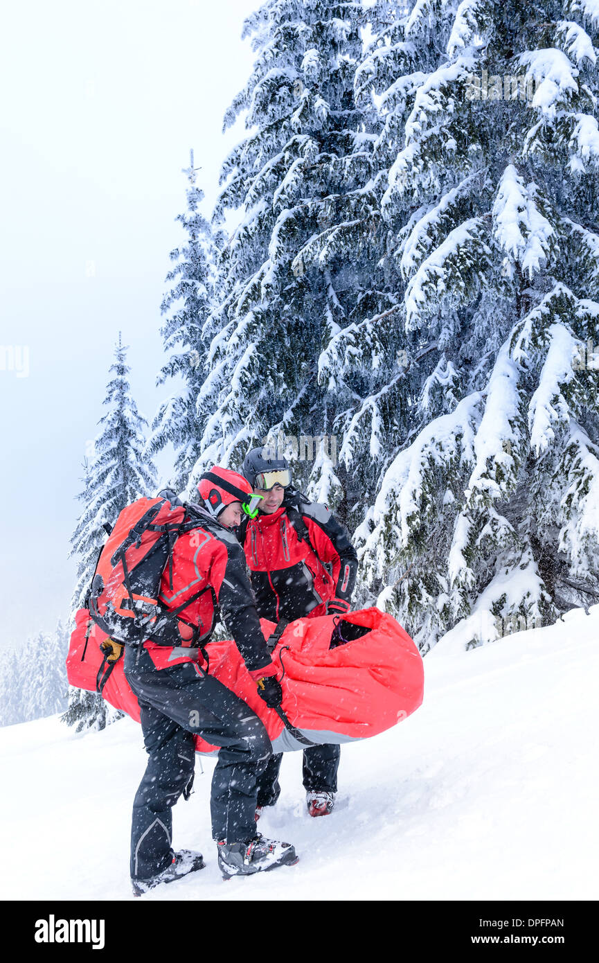Ski Patrol transporter blessés skieur dans la neige de civière de sauvetage Banque D'Images