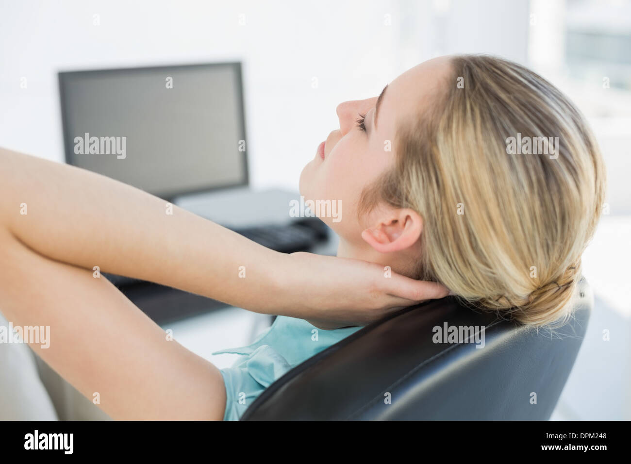 Chic détente femme assise sur son fauteuil pivotant Banque D'Images