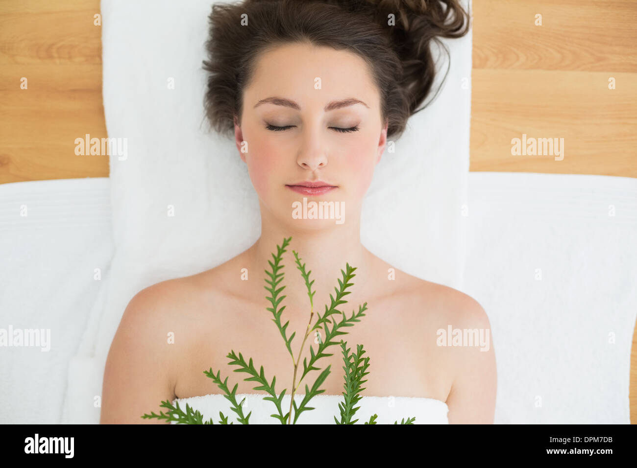 Brunette lying avec feuilles en instituts de beauté Banque D'Images