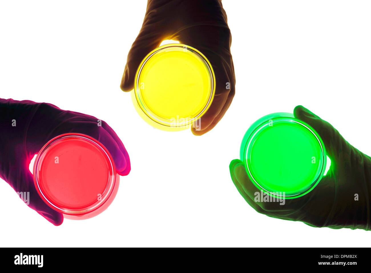 Mains Gants avec un ballon avec des produits chimiques liquides colorés Banque D'Images