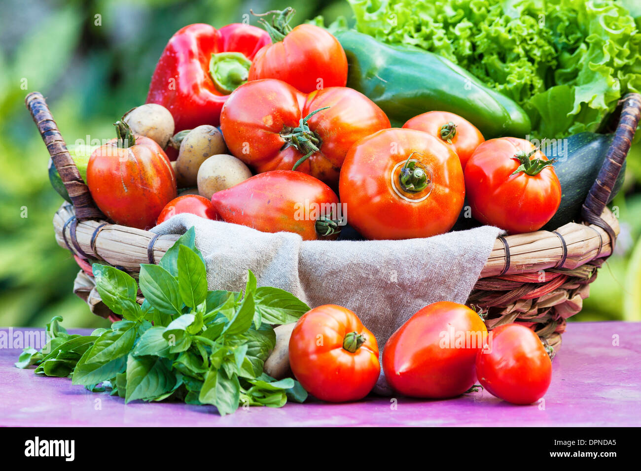 Les légumes dans un panier sur la table sous la lumière du soleil Banque D'Images