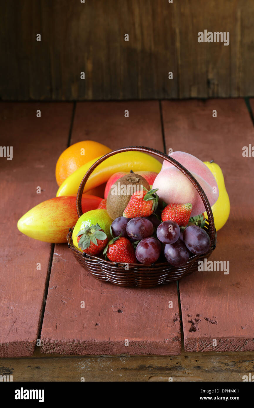 Still Life panier en osier avec des fruits sur une table en bois Banque D'Images
