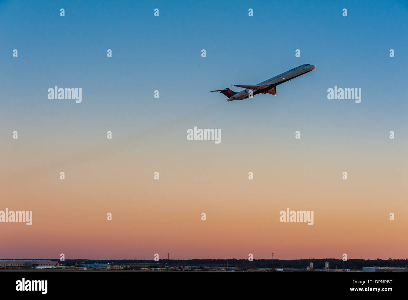 Delta Airlines jet décollant de l'aéroport international Hartsfield-Jackson Atlanta contre un ciel magnifiquement coloré au coucher du soleil. (ÉTATS-UNIS) Banque D'Images