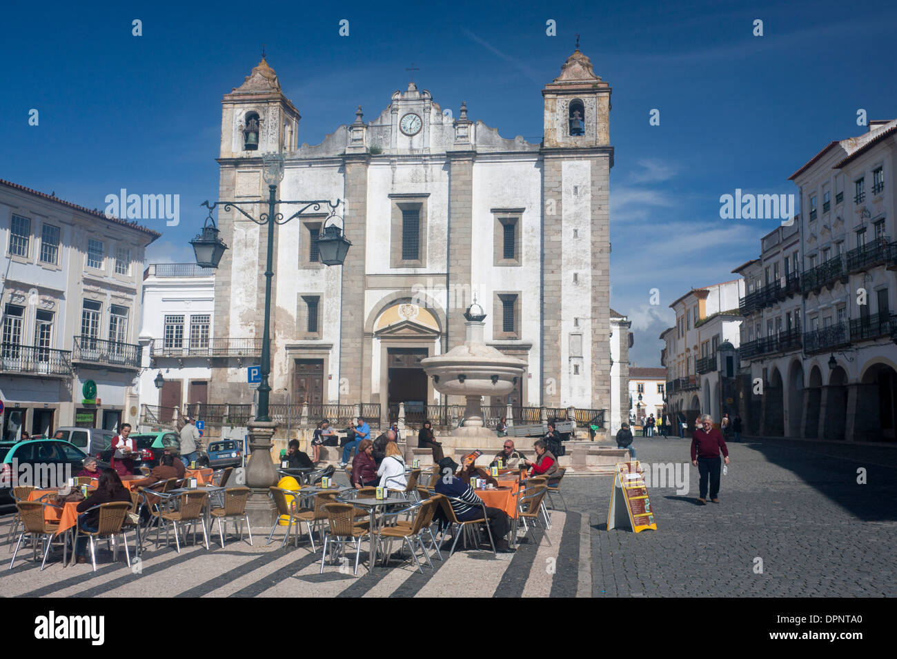 Évora Praça do Giraldo carré avec les gens au café cafés tables et de l'église Igreja da Santo Antão Alentejo Portugal Banque D'Images