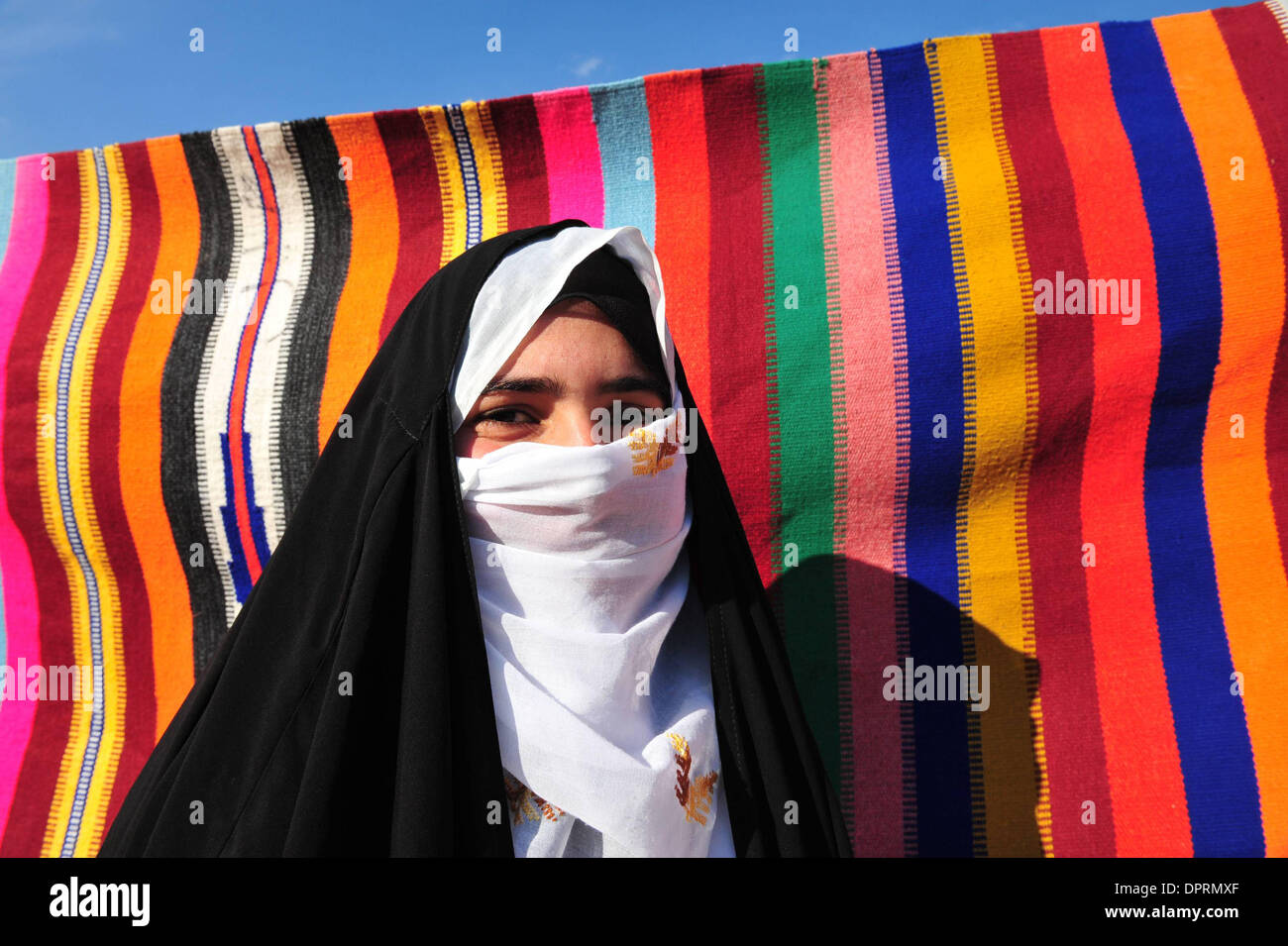 Nov 25, 2008 - Rahat, Israël - Femme portant burqa la vente de tapis et de poteries enveloppé dans du tissu. En Israël, des dizaines de milliers de Bédouins arabes craignent que le gouvernement israélien veut s'approprier des terres qu'ils disent leur appartient et de mettre fin à leur mode de vie nomade traditionnel. Les Bédouins arabes israéliens sont 160 000 citoyens israéliens, qui vivent dans ce qu'on appelle des "villages non reconnus" t Banque D'Images
