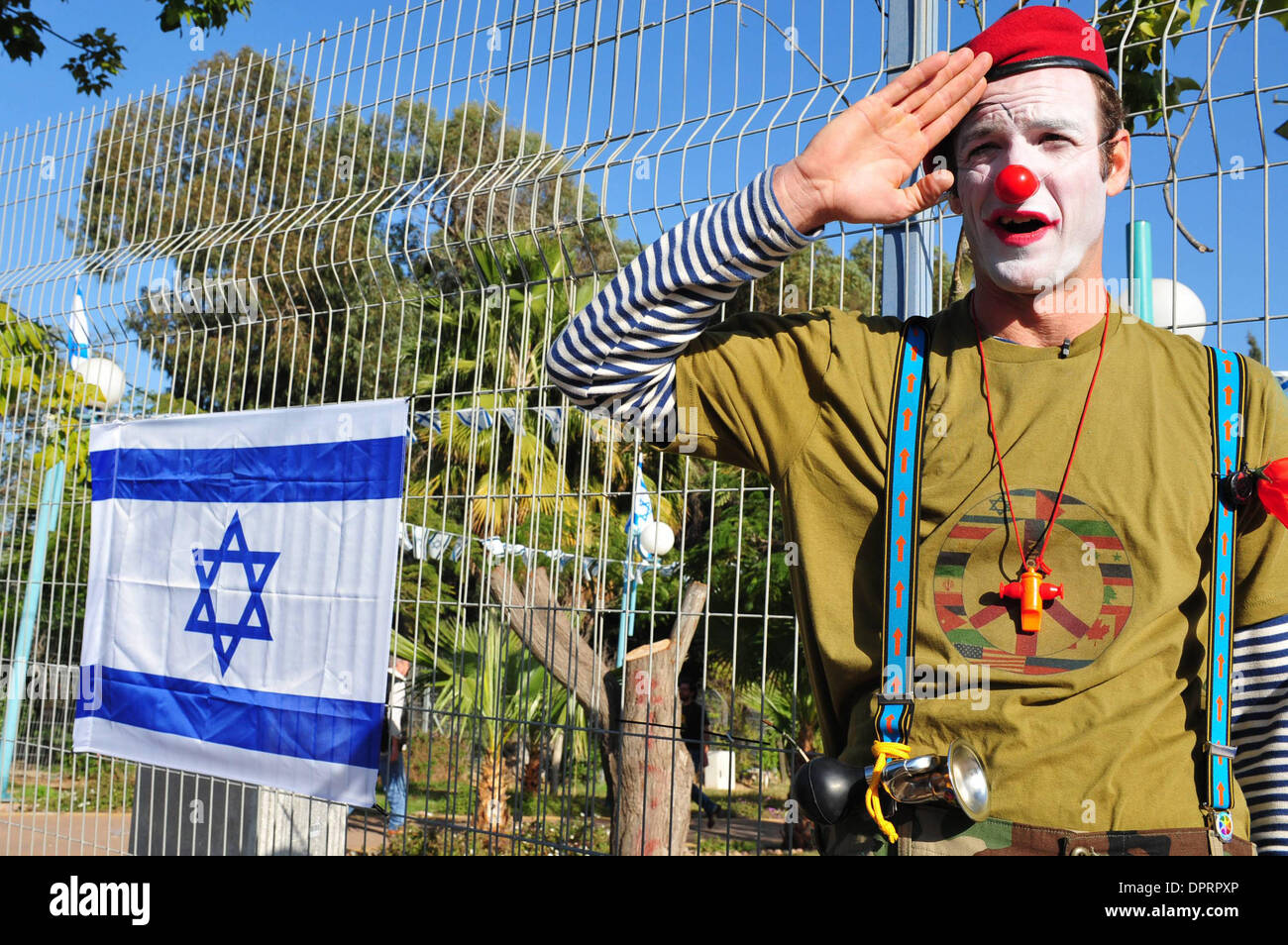 Jan 07, 2009 - Israël - un clown divertit les enfants dans le sud d'Israël tout en se tenant debout à côté d'un drapeau israélien, l'un des nombreux qui sont actuellement suspendus partout en Israël pour le patriotisme. Les enfants dans le sud d'Israël dans un rayon de 40 km de la bande de Gaza ne peuvent pas aller à l'école et vivent dans des abris. Les enfants participeront par l'armée israélienne, groupes, artistes et f Banque D'Images