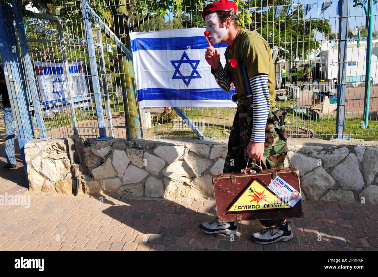 Jan 07, 2009 - Israël - un clown divertit les enfants dans le sud d'Israël tout en se tenant debout à côté d'un drapeau israélien, l'un des nombreux qui sont actuellement suspendus partout en Israël pour le patriotisme. Les enfants dans le sud d'Israël dans un rayon de 40 km de la bande de Gaza ne peuvent pas aller à l'école et vivent dans des abris. Les enfants participeront par l'armée israélienne, groupes, artistes et f Banque D'Images