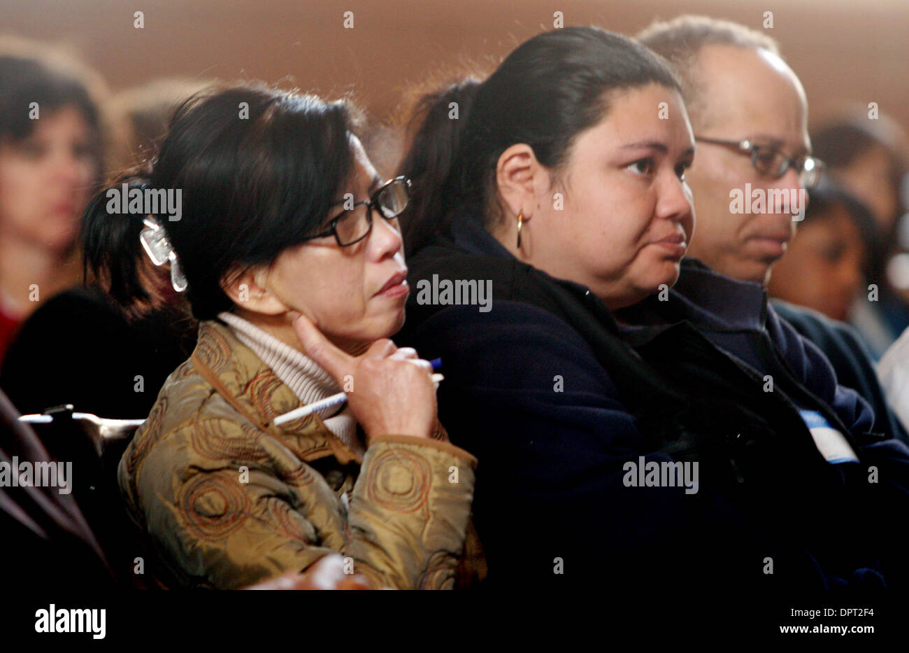 Dung Tran, tante de deux septième et huitième année, filles et Fila Enciso, parent d'une huitième année, écouter attentivement, ville et comté dirigeants parler de réforme de l'éducation pour le financement des études à la lumière de la crise du budget de l'état Mercredi, 4 février 2009, dans l'auditorium de l'école intermédiaire de Roosevelt à Oakland, Californie (Laura A. Oda/personnel) Banque D'Images