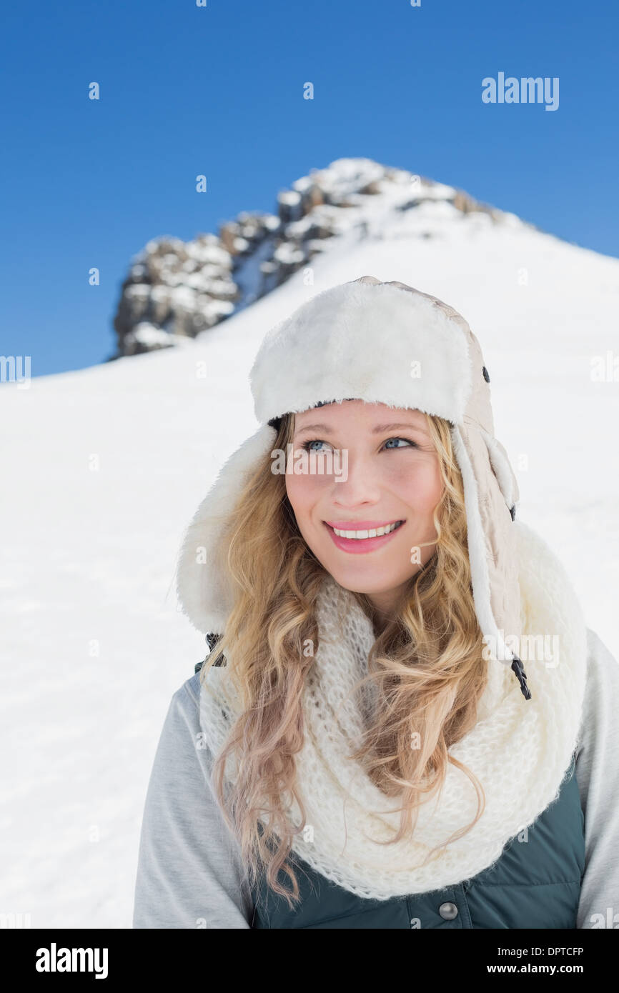 Femme souriante en face de la colline de neige et ciel bleu clair Banque D'Images