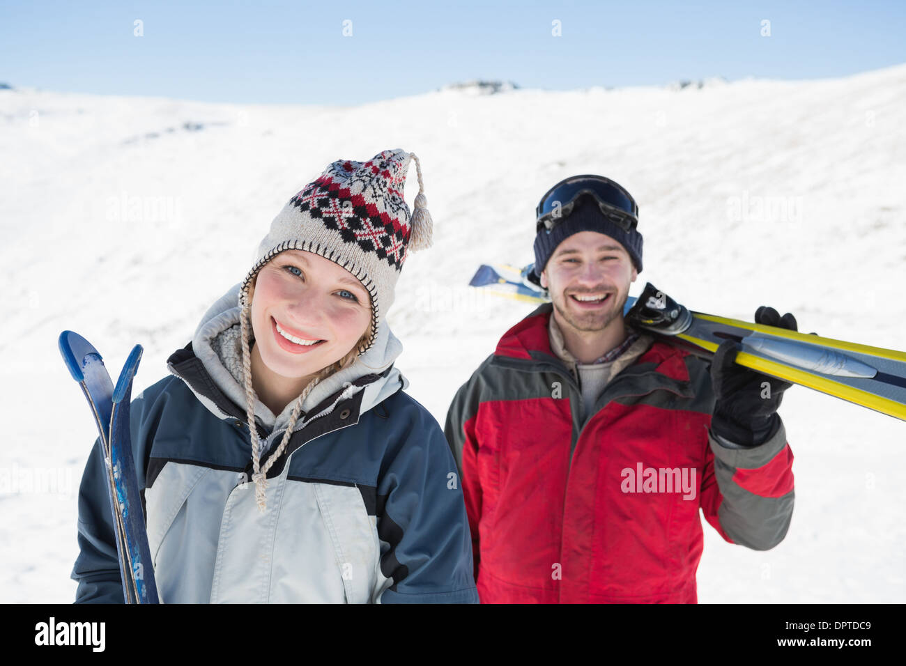 Portrait of a smiling couple avec conseils de ski neige nn Banque D'Images