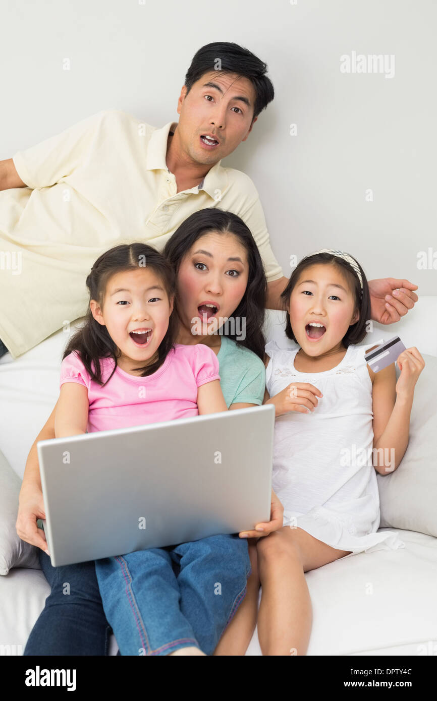 Portrait de famille de quatre choqué de faire les achats en ligne Banque D'Images