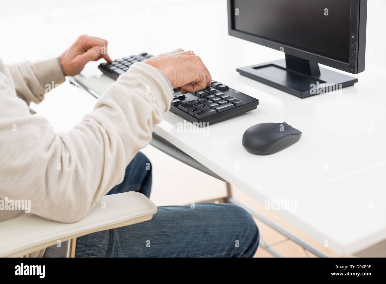 Vue de côté mid section d'un homme à l'aide du clavier de l'ordinateur Banque D'Images