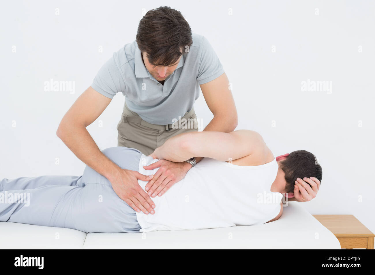 Physiotherapist examining Male mans retour Banque D'Images