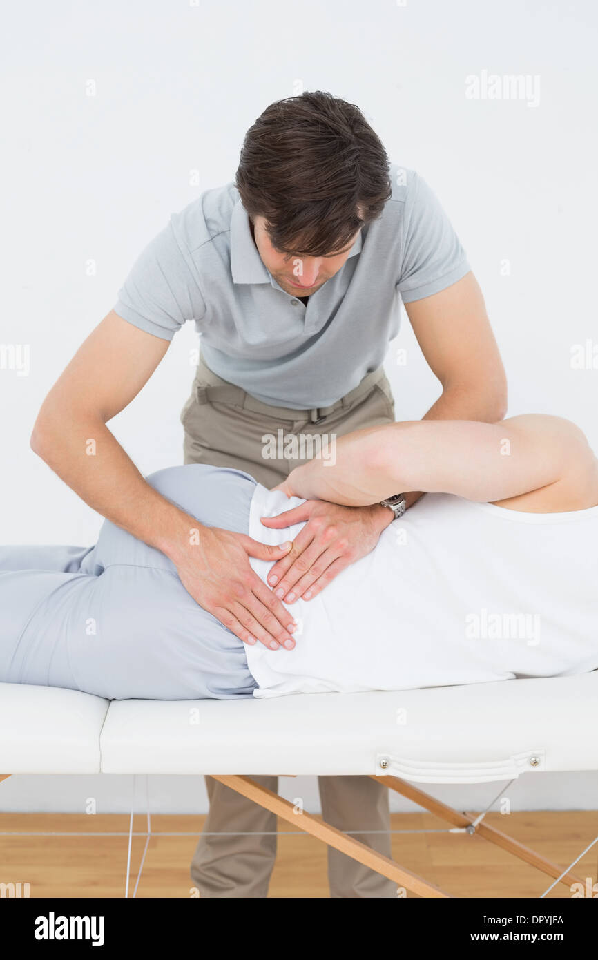 Physiotherapist examining Male mans retour Banque D'Images