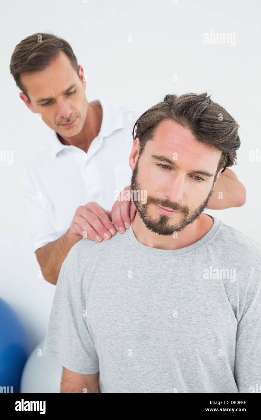 Homme therapist massaging a content man's shoulders Banque D'Images