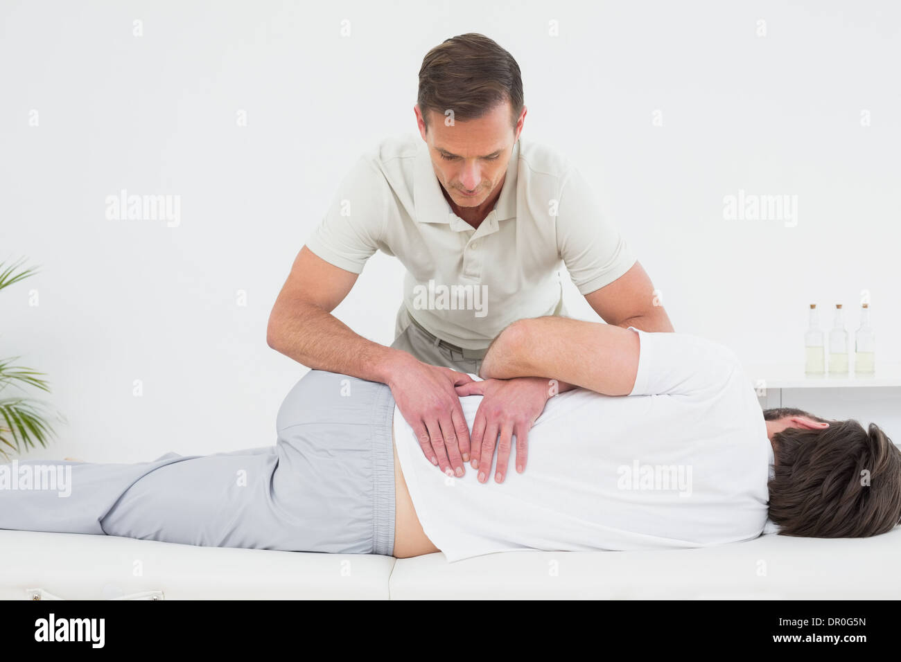 Physiotherapist examining Male man's back Banque D'Images