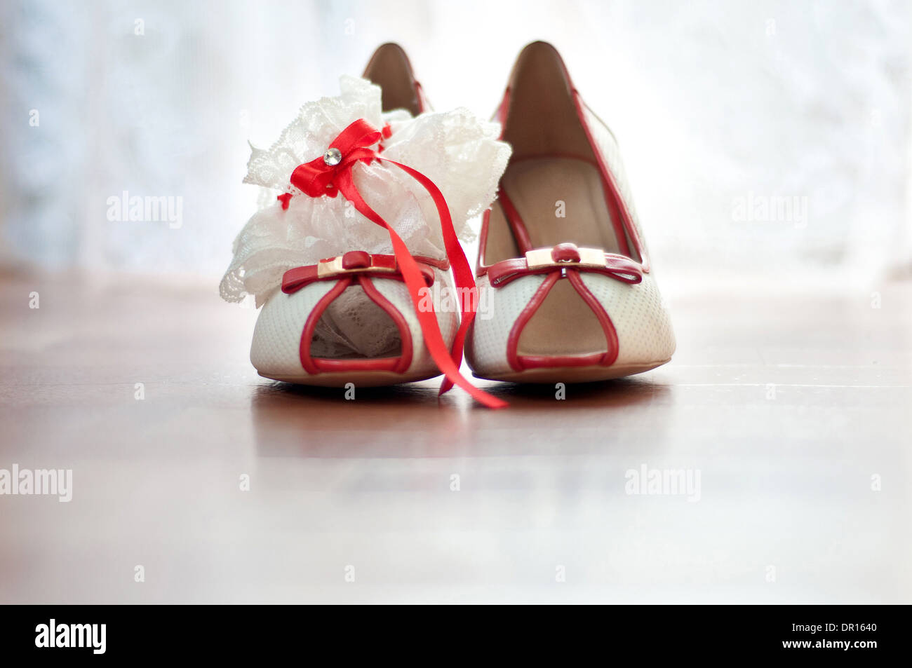 Chaussures rouges et porte-jarretelles de la mariée Banque D'Images