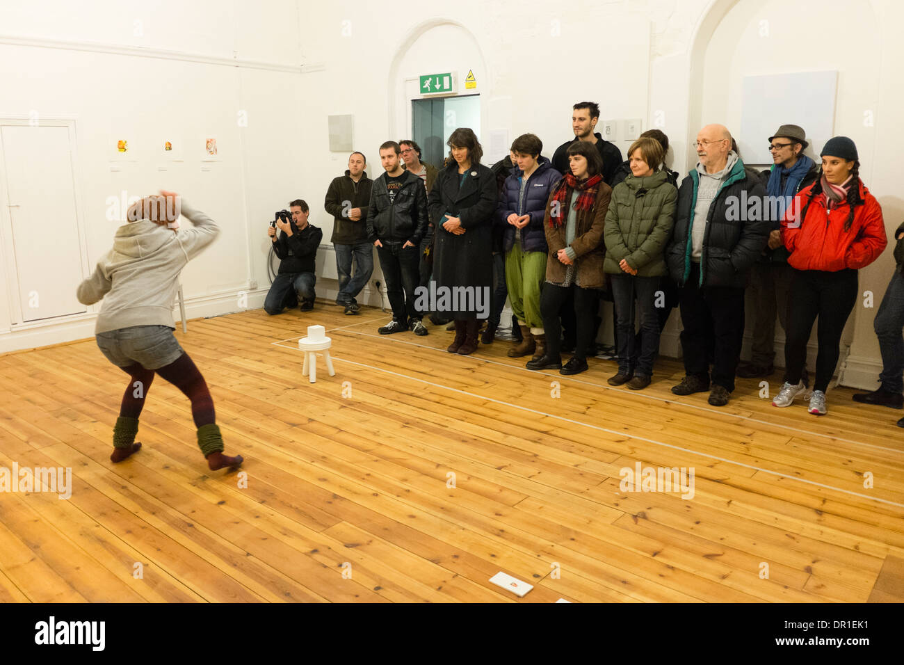 Performance Art - les gens qui regardent une femme artiste performing live art dans une galerie UK Banque D'Images