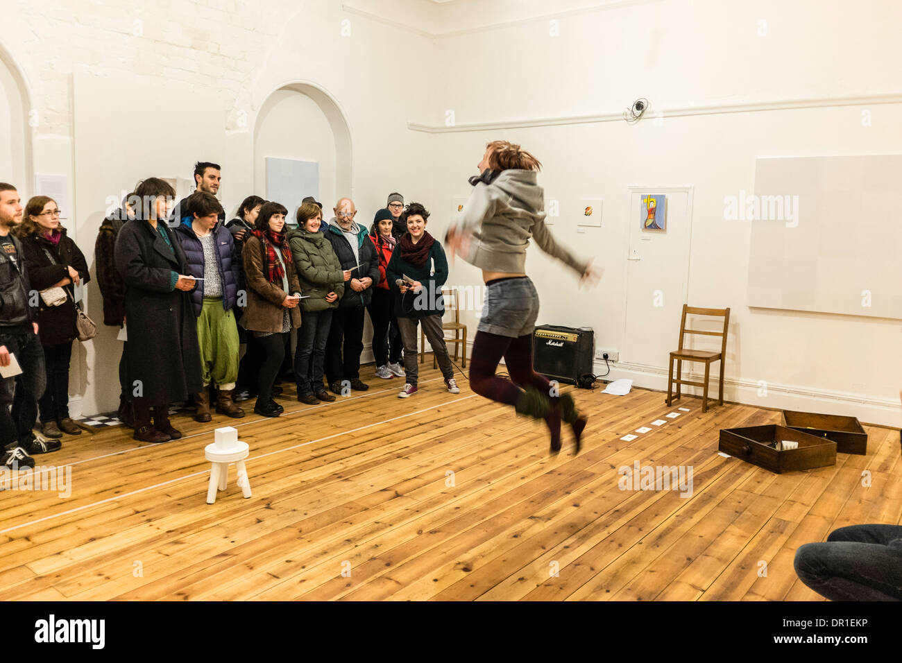 Performance Art - les gens qui regardent une femme artiste performing live art dans une galerie UK Banque D'Images